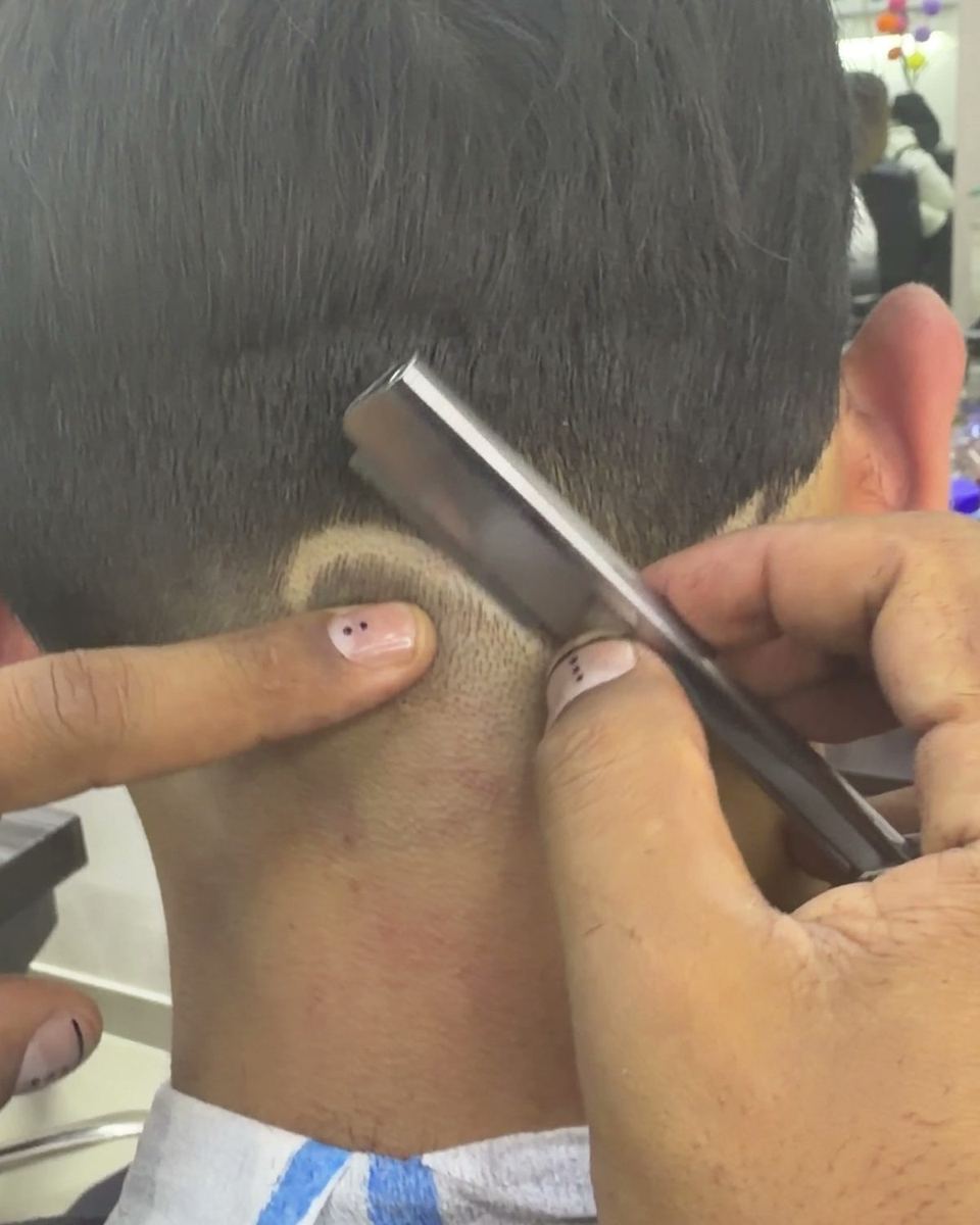 Perfilado con navaja hecho en la barbería del salón
